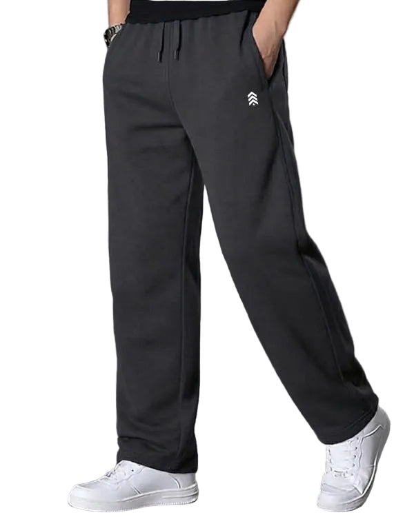 Person wearing dark gray sweatpants with a logo on a gray background