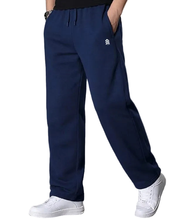 Person wearing blue pants with a logo and white sneakers on a gray background